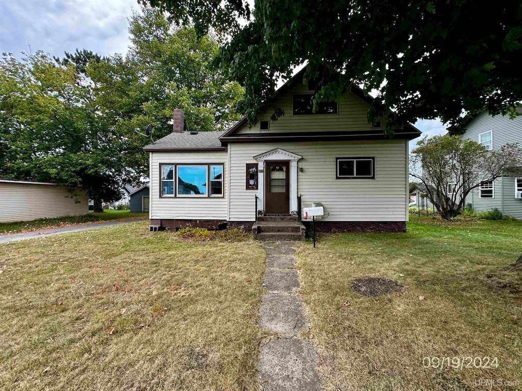 bungalow-style home featuring a front yard