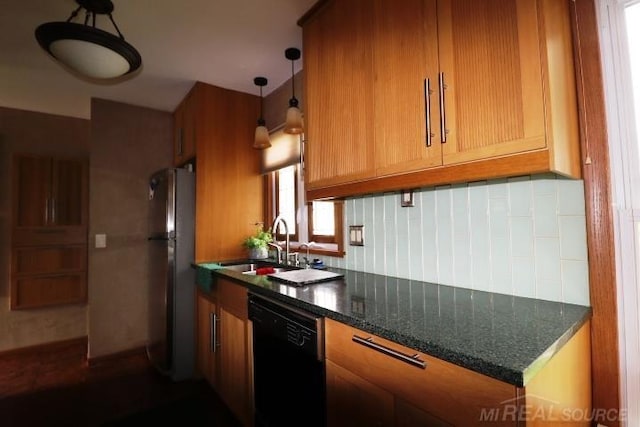 kitchen featuring hanging light fixtures, stainless steel refrigerator, black dishwasher, dark stone counters, and sink