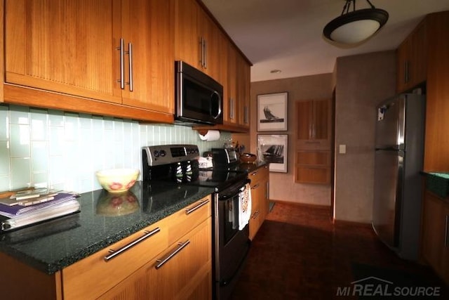 kitchen featuring appliances with stainless steel finishes, dark stone countertops, and tasteful backsplash