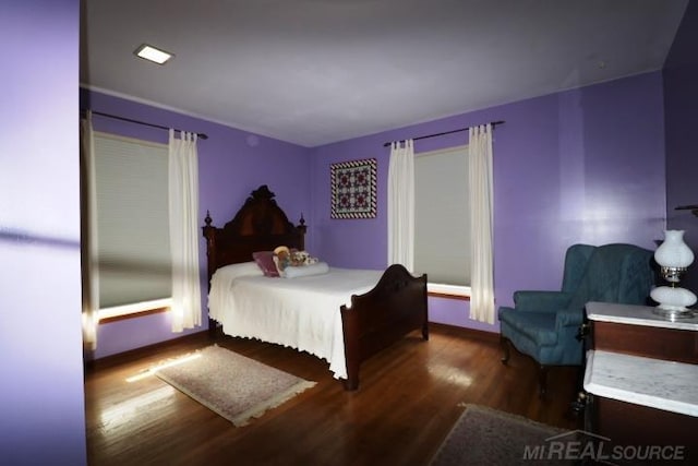 bedroom with dark hardwood / wood-style flooring