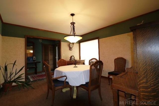 carpeted dining room with ornamental molding