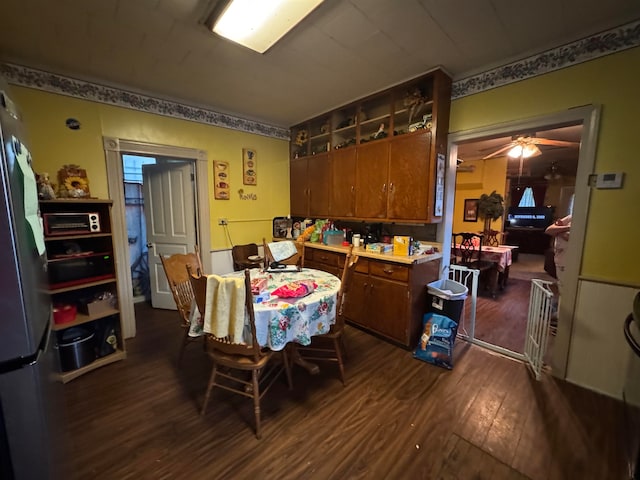 dining space with ceiling fan and dark hardwood / wood-style floors