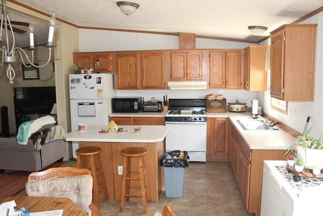 kitchen with lofted ceiling, sink, white appliances, a breakfast bar area, and ornamental molding