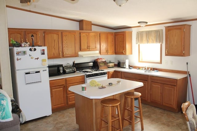 kitchen featuring a breakfast bar, sink, a center island, vaulted ceiling, and white appliances