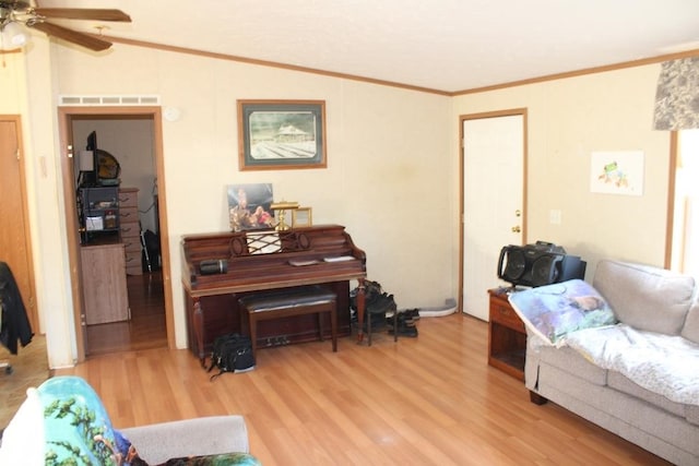 living room with ceiling fan, ornamental molding, vaulted ceiling, and light hardwood / wood-style flooring