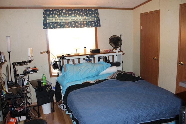 bedroom with hardwood / wood-style floors and ornamental molding