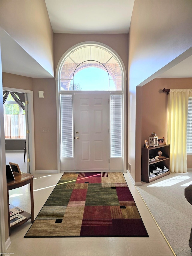 foyer featuring plenty of natural light and carpet