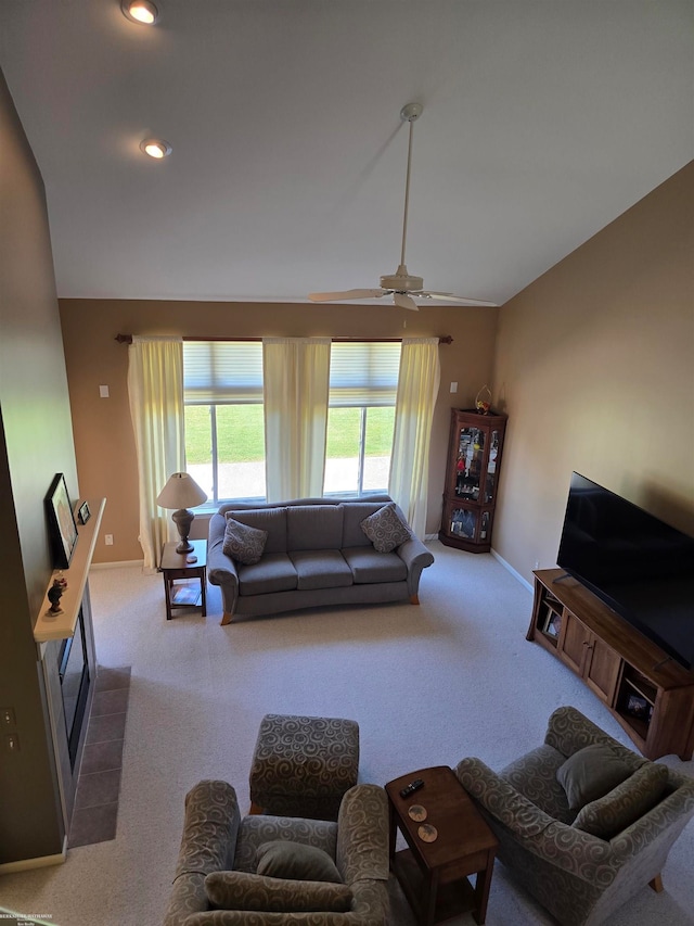 carpeted living room featuring ceiling fan and a tile fireplace