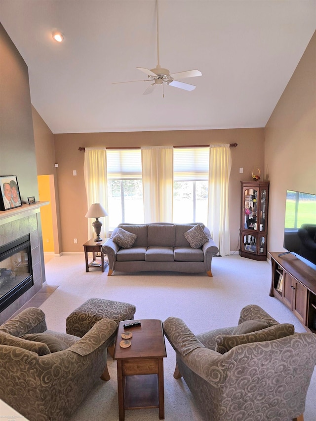 carpeted living room featuring ceiling fan, a fireplace, and high vaulted ceiling