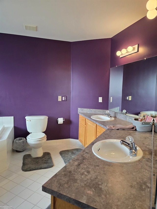 bathroom with tile patterned flooring, a bath, vanity, and toilet