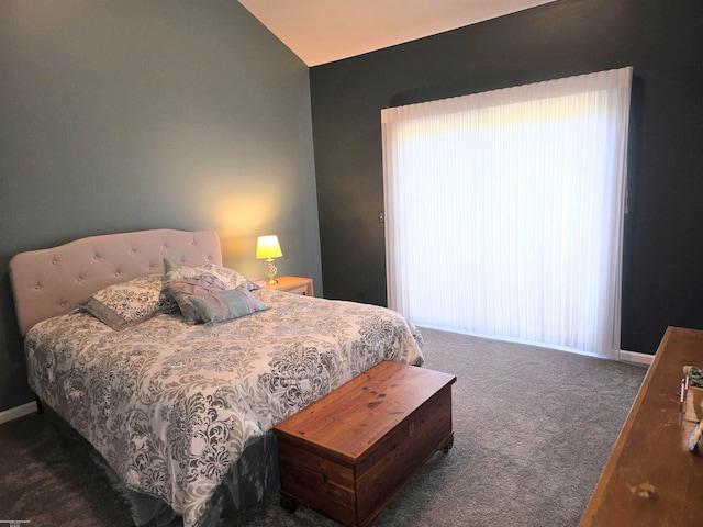 bedroom featuring dark colored carpet and lofted ceiling