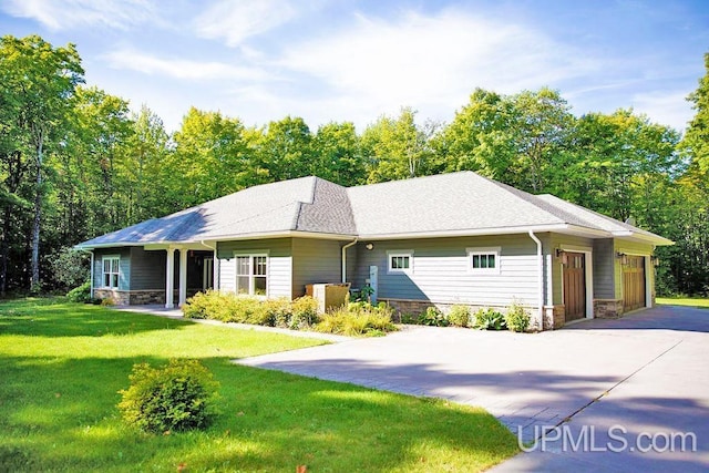 single story home featuring a garage and a front lawn