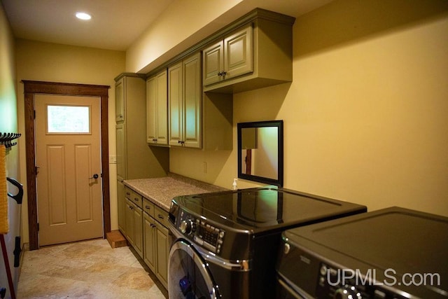 laundry area with separate washer and dryer and cabinets