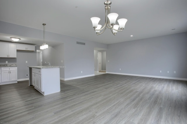 kitchen with hanging light fixtures, white cabinetry, light hardwood / wood-style flooring, and a notable chandelier