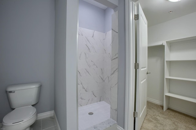 bathroom featuring a tile shower and toilet