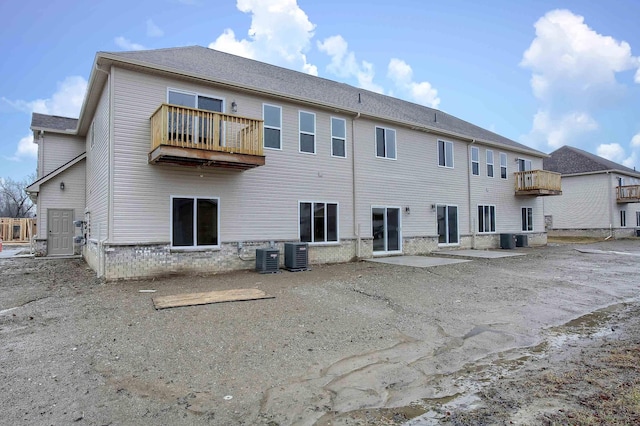 back of house featuring cooling unit and a balcony