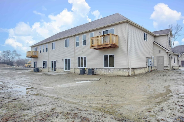 back of property featuring a balcony and central AC unit