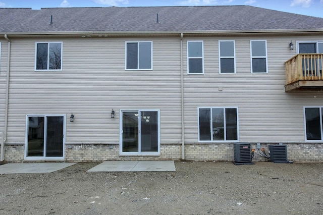 rear view of property featuring central AC unit, a balcony, and a patio area