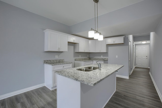 kitchen with an island with sink, white cabinetry, dark hardwood / wood-style floors, and sink