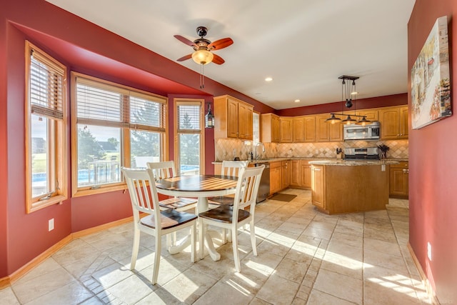 dining room featuring ceiling fan, sink, and a wealth of natural light