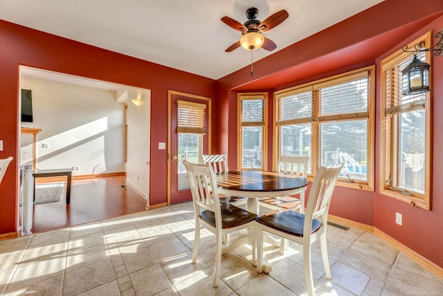 dining area featuring light wood-type flooring, ceiling fan, and a healthy amount of sunlight