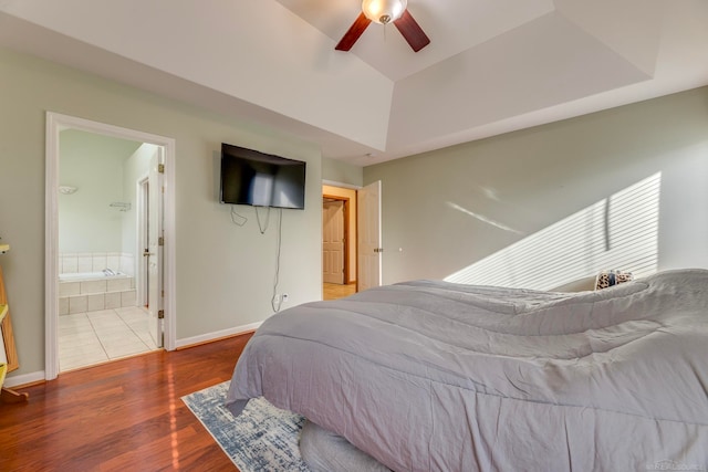 bedroom featuring connected bathroom, dark hardwood / wood-style floors, and ceiling fan