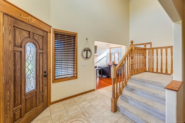 tiled foyer with a towering ceiling