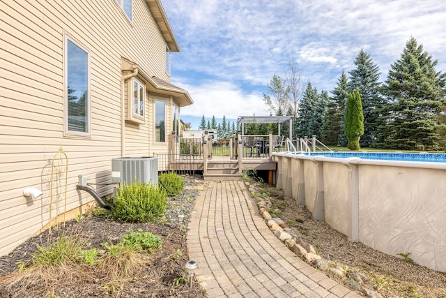 view of yard with a pool side deck and cooling unit