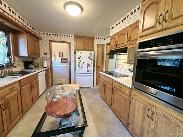 kitchen featuring backsplash, a baseboard heating unit, white appliances, and sink