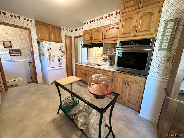 kitchen with tasteful backsplash, oven, stovetop, a baseboard radiator, and white fridge