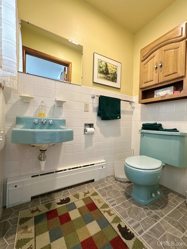 bathroom featuring tile walls, tile patterned flooring, toilet, and sink