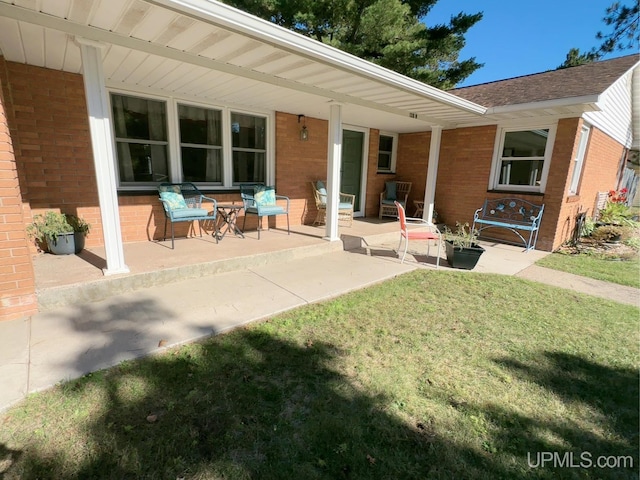 back of property featuring a lawn and a patio area