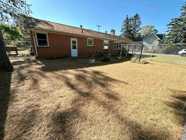 rear view of house featuring a patio area and a yard