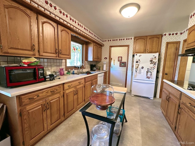 kitchen with decorative backsplash, white appliances, and sink