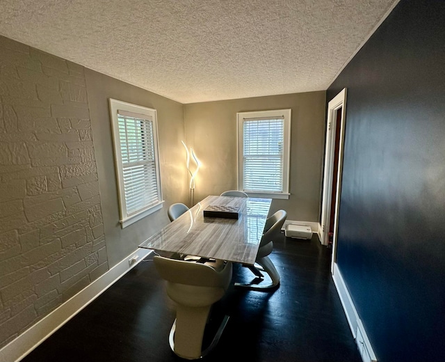 dining space with a textured ceiling and dark hardwood / wood-style flooring