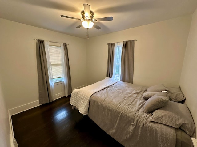 bedroom with dark hardwood / wood-style floors and ceiling fan