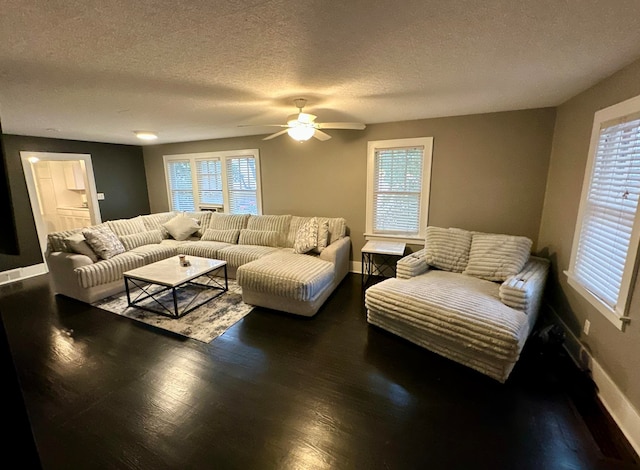 living room featuring a wealth of natural light, ceiling fan, a textured ceiling, and dark hardwood / wood-style flooring