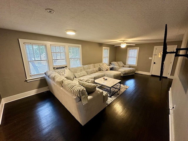 living room with ceiling fan, a textured ceiling, and dark hardwood / wood-style flooring