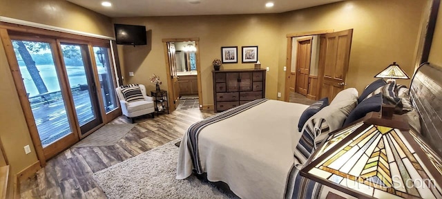 bedroom with dark hardwood / wood-style floors, ensuite bath, and access to exterior