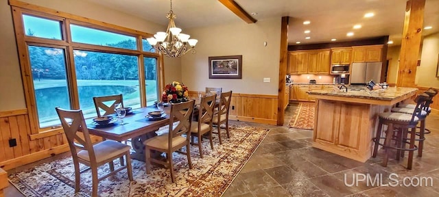 dining room with an inviting chandelier and wooden walls