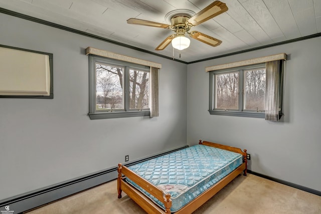 carpeted bedroom with crown molding, a baseboard heating unit, and ceiling fan