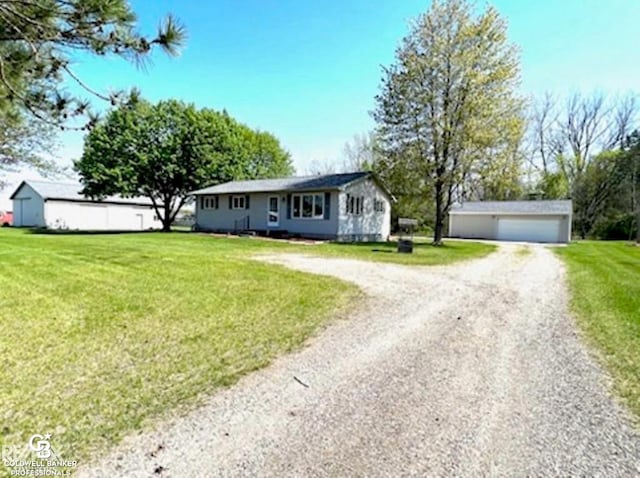 single story home with a garage, a front lawn, and an outbuilding