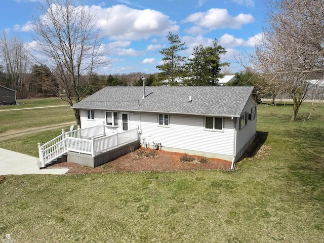 back of property with a deck and a yard