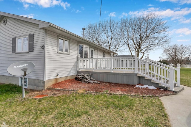 view of property exterior featuring a deck and a yard