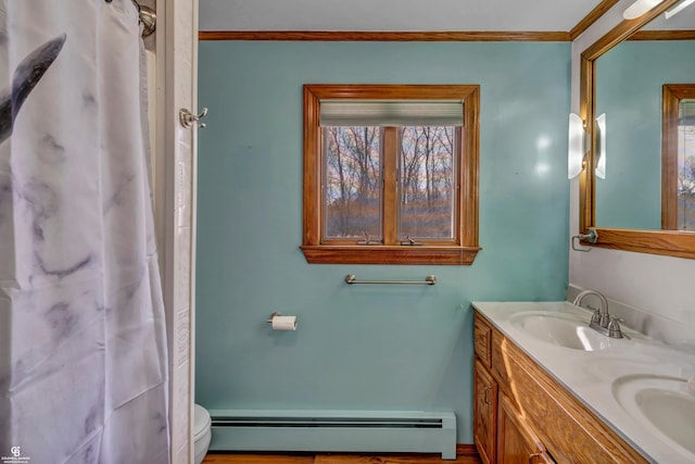 bathroom featuring plenty of natural light, vanity, toilet, and a baseboard radiator