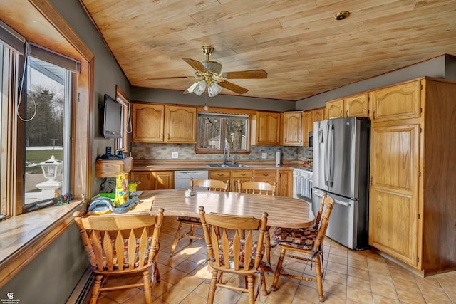 kitchen with stainless steel fridge, light tile patterned floors, and a healthy amount of sunlight