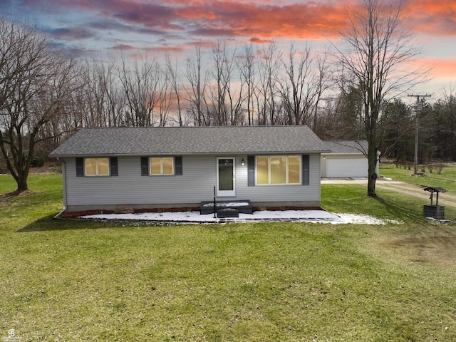 single story home featuring a garage and a lawn