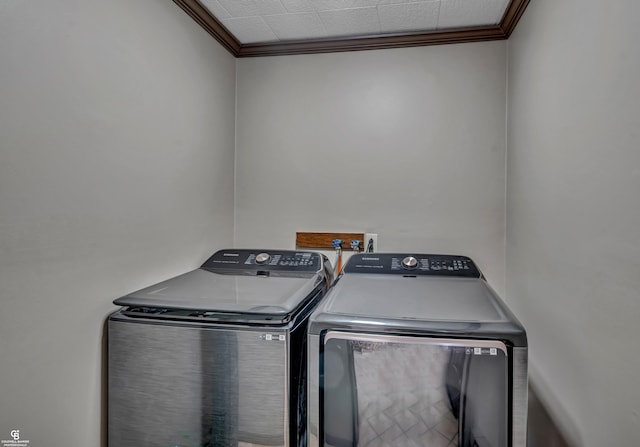 clothes washing area featuring ornamental molding and washing machine and dryer