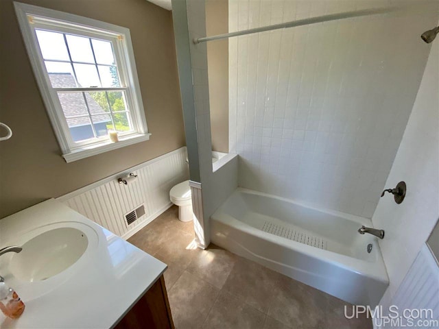 full bathroom with tiled shower / bath, vanity, and toilet