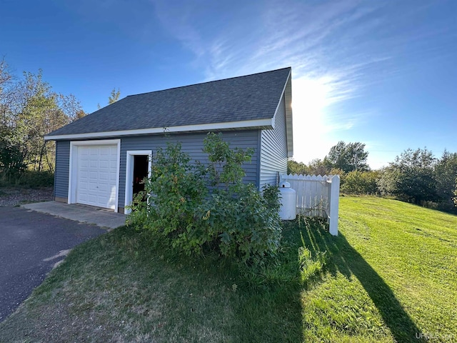 view of home's exterior featuring a yard, an outdoor structure, and a garage